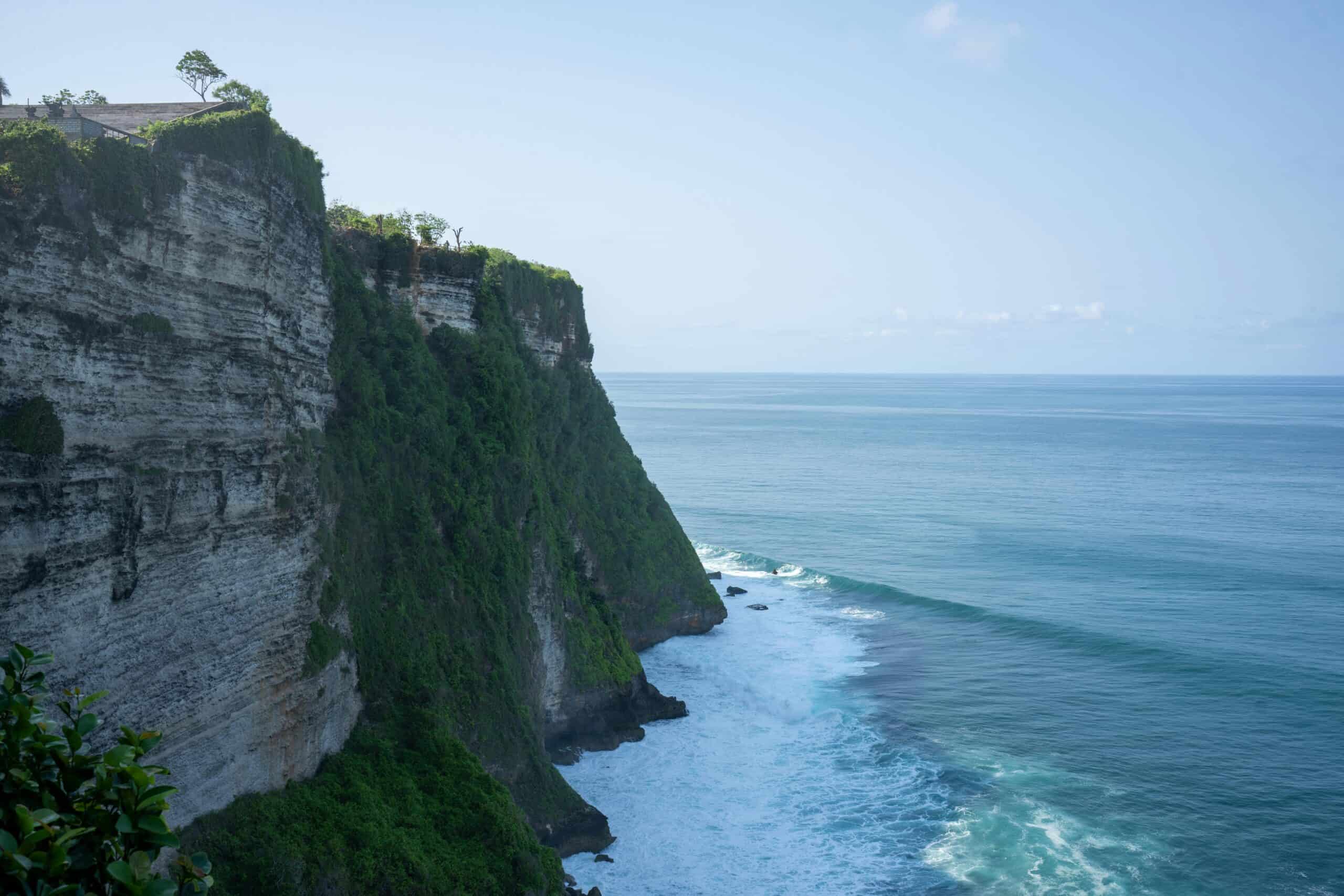 Eerste keer Bali: wat je moet weten (complete gids 2026) Breathtaking view of Uluwatu Cliffs meeting the Indian Ocean in Bali, Indonesia.